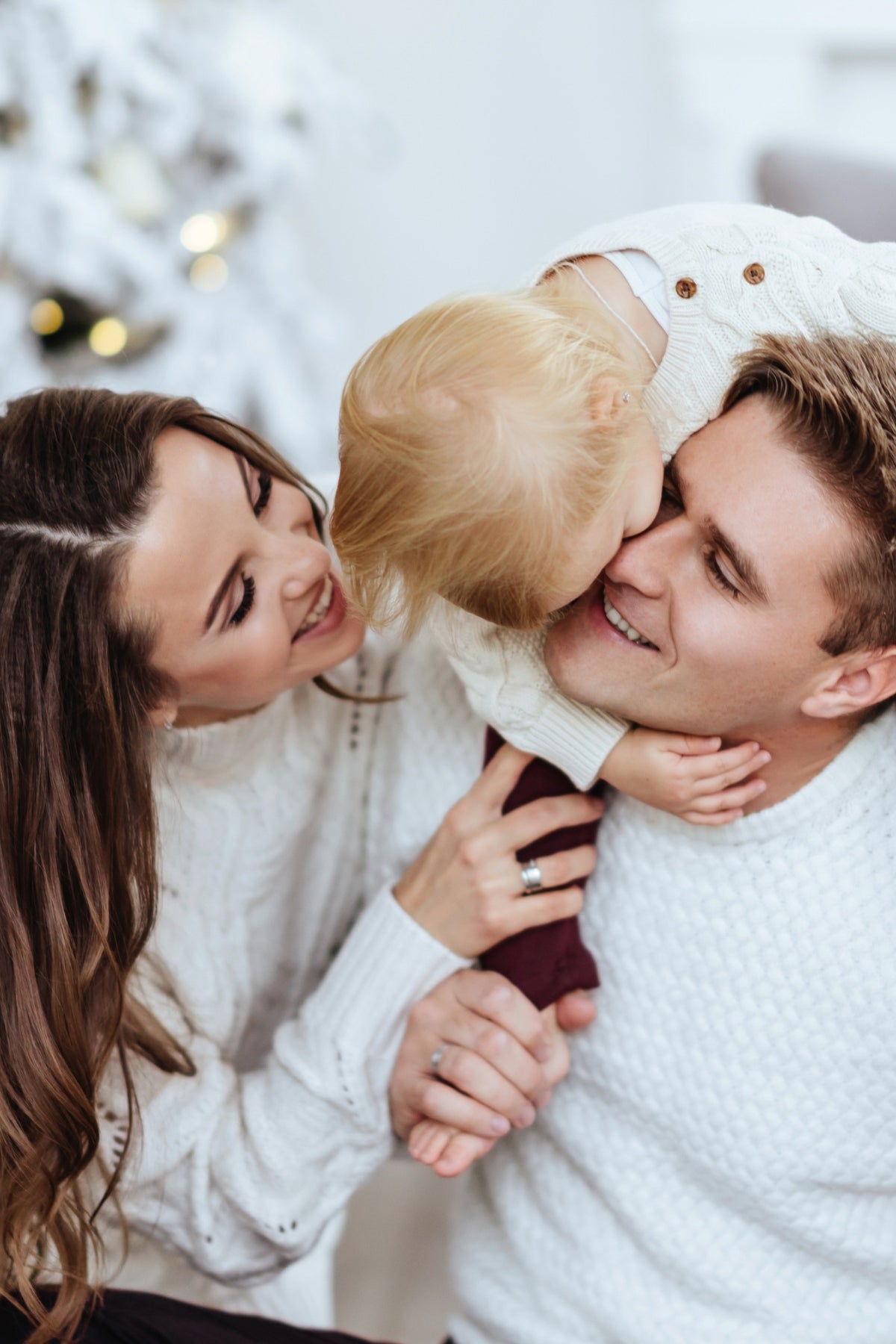 Family sitting on couch with child, sharing joy.